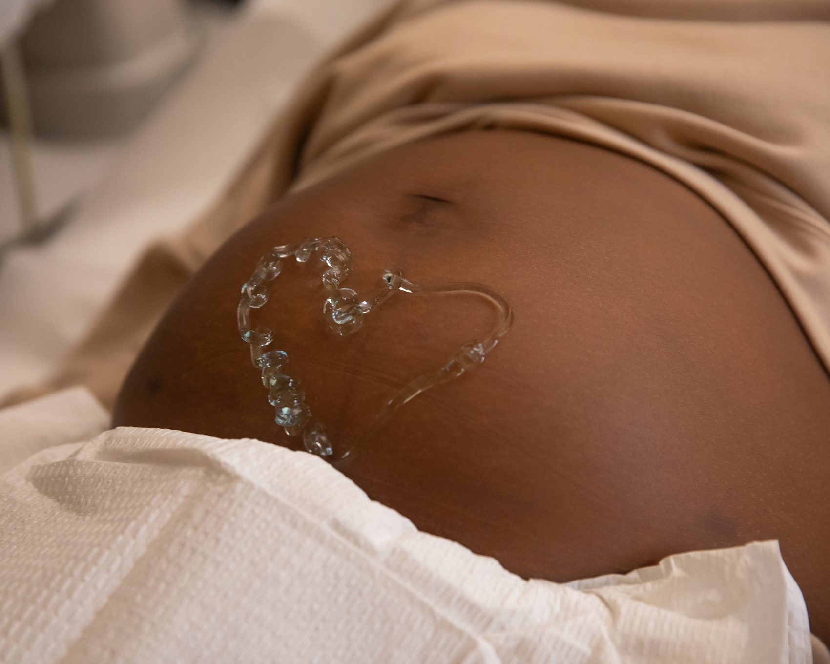 Expectant mother with an ultrasound photo and a heart on her belly